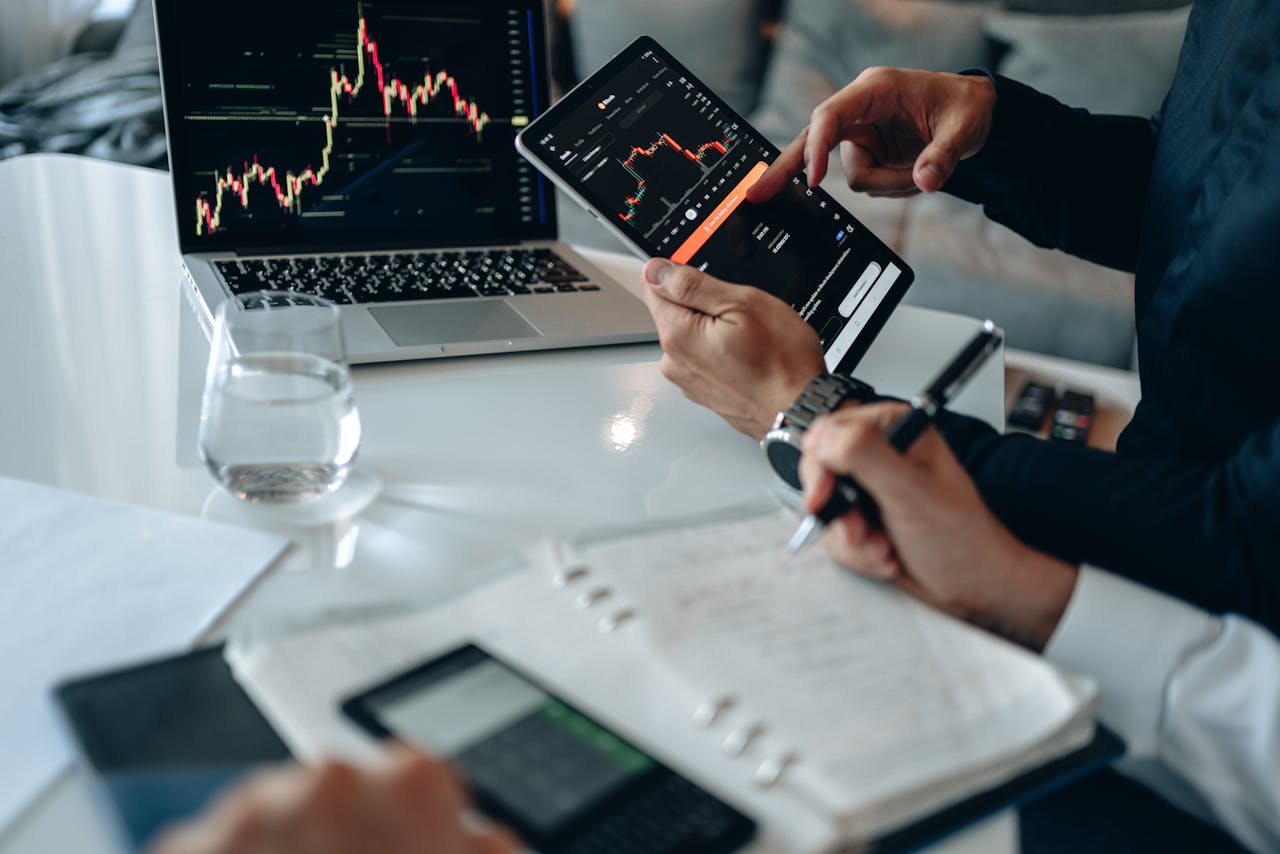 Offerings Business professionals reviewing financial charts on digital devices in a modern office setting.