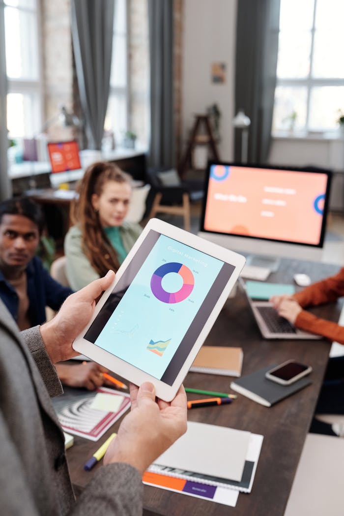 Offerings Colleagues reviewing business data on a tablet in a modern office setting.
